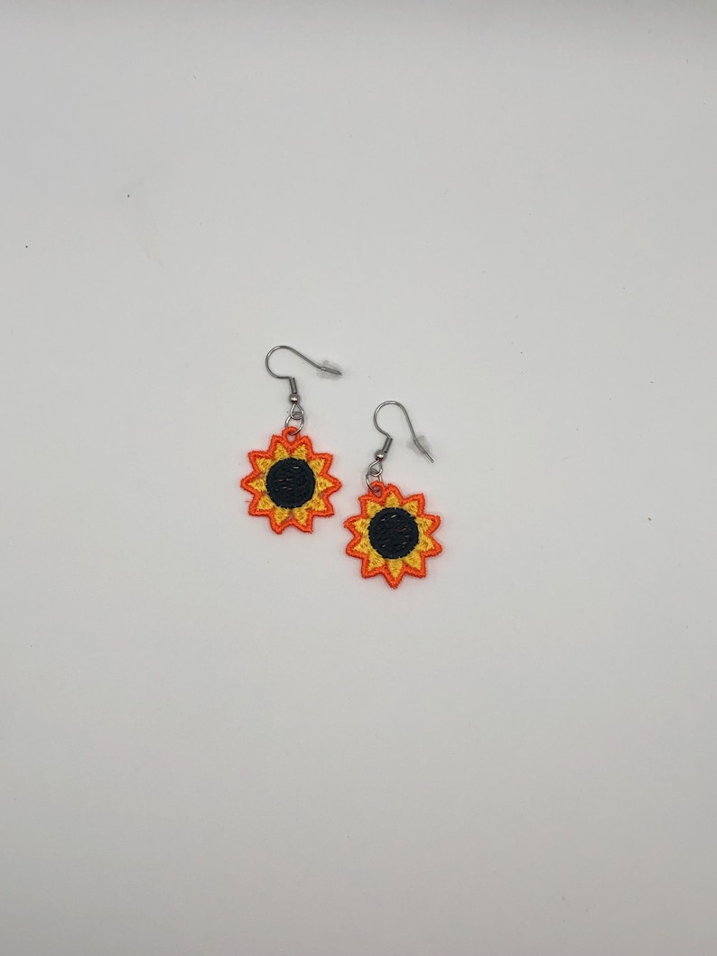 Yellow sunflower lace earrings crafted with vibrant embroidery thread to make a stunning addition to any outfit, adding a feminine and delicate touch. These earrings are super lightweight, unique, and make a wonderful gift for any occasion. The hypoallergenic French ear wire hooks and jump rings are made from stainless steel and include clear silicone earring backs. Measurements: Refer to Size / Select an option
