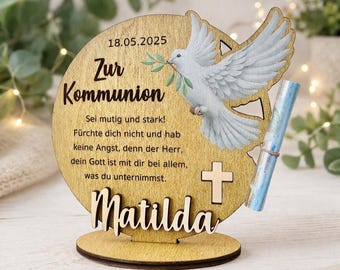 May include: A wooden Communion keepsake with a dove carrying an olive branch. The text includes the date 05/18/2025, the name "Matilda", and a religious message. A scroll is attached to the side.