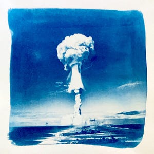 Könnte beinhalten: Ein blaues und weißes Foto einer Pilzwolke, die aus dem Meer aufsteigt. Die Wolke ist groß und weiß, mit einem dunkelblauen Himmel dahinter.