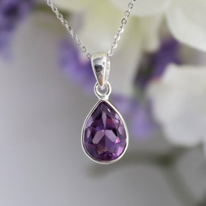 K&ouml;nnte beinhalten: Eine silberne Kettenkette mit einem tropfenf&ouml;rmigen Amethyst-Anh&auml;nger.