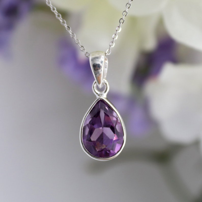 K&ouml;nnte beinhalten: Eine silberne Kettenkette mit einem tropfenf&ouml;rmigen Amethyst-Anh&auml;nger.