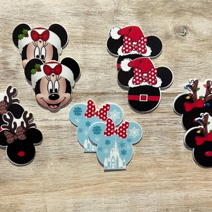 Peut inclure: Un ensemble de dix découpes de tête de Minnie Mouse sur le thème de Noël. Les découpes représentent Minnie Mouse portant un chapeau de Père Noël, un bandeau de renne et une tenue d'hiver bleue et blanche. Les découpes sont parfaites pour décorer pour les fêtes.