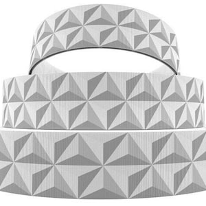 May include: Three rolls of white grosgrain ribbon with a geometric pattern. The ribbon has a 3D effect and is perfect for crafting and decorating.