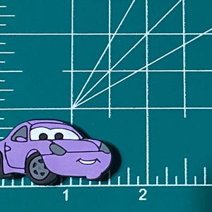 May include: A purple cartoon car with a smiling face. The car has black wheels and a black windshield.