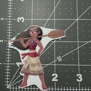 May include: A cartoon illustration of Moana from the Disney movie Moana. She is wearing a brown and red outfit with a blue necklace and holding a wooden paddle.