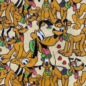 May include: A beige fabric with a repeating pattern of cartoon dogs. The dogs are brown and yellow with black eyes and noses. They are wearing green collars and some have a green hat. The text "CAP'N" is on the collar of one of the dogs.