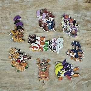 Puede incluir: Una colección de recortes de madera de personajes de Disney con temática de Halloween. Los personajes incluyen Mickey Mouse, Minnie Mouse, Pluto, Goofy y Winnie the Pooh. Los recortes están pintados en varios colores, incluyendo rojo, naranja, amarillo, verde, azul y morado. Los recortes son perfectos para decorar para Halloween.