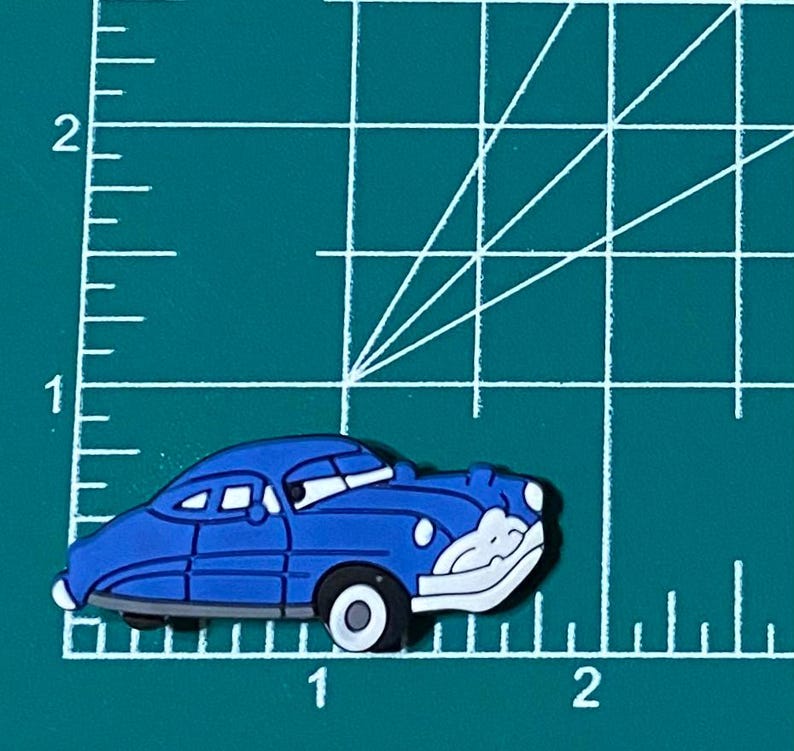May include: A blue cartoon car with white headlights and a white windshield. The car has a black stripe along the side and black wheels.