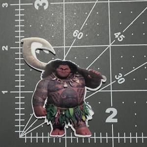 May include: A cartoon character from the movie Moana, Maui, is depicted in a sticker. He is a muscular Polynesian man with brown skin, black hair, and a large hook in his hand. He is wearing a green and brown grass skirt and a necklace with a shell pendant. He has a tattoo on his chest and a fierce expression on his face.