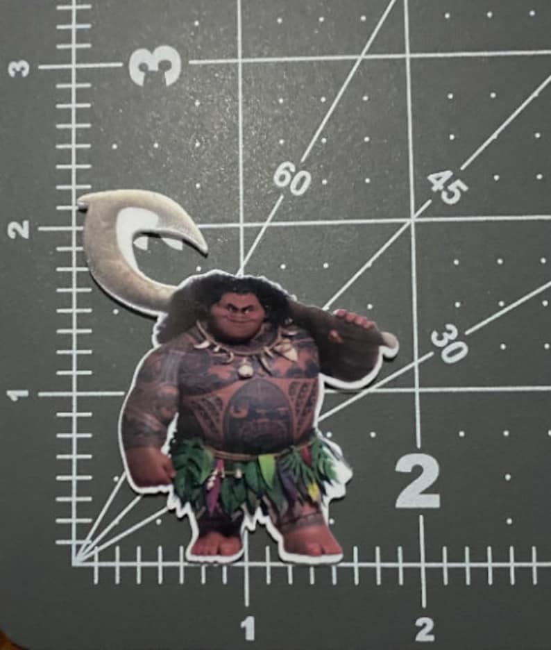 May include: A cartoon character from the movie Moana, Maui, is depicted in a sticker. He is a muscular Polynesian man with brown skin, black hair, and a large hook in his hand. He is wearing a green and brown grass skirt and a necklace with a shell pendant. He has a tattoo on his chest and a fierce expression on his face.