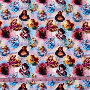 May include: Fabric with a repeating pattern of cartoon princesses, fairies, and other characters on a colorful, watercolor-style background. The princesses include Snow White, Cinderella, and others. A pink measuring tape is at the bottom.