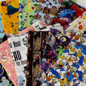 May include: A collection of colorful fabric squares featuring various Disney characters, including Mickey Mouse, Donald Duck,  and characters from the movies "Inside Out", "Up", "Cars", "Nightmare Before Christmas", and "The Haunted Mansion".