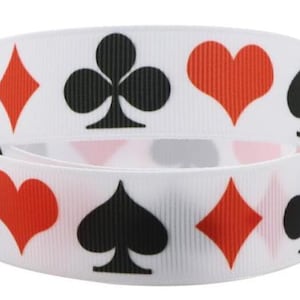 Könnte beinhalten: Weißes Band mit sich wiederholenden Mustern von Spielkartenfarben: rote Herzen und Rauten, sowie schwarze Kreuz und Pik. Ideal zum Basteln, Geschenkverpacken oder Verzieren.