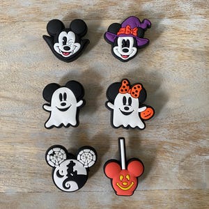 K&ouml;nnte beinhalten: Sechs Halloween-Schuhanh&auml;nger mit Mickey und Minnie Mouse. Designs umfassen einen Hexenhut, einen Geist und S&uuml;&szlig;igkeiten. Die Farbpalette umfasst Schwarz, Wei&szlig;, Orange und Lila. Ideal, um Schuhen eine festliche Note zu verleihen.
