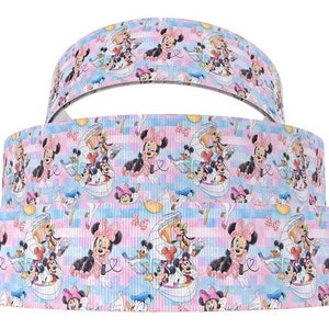 Pode incluir: Um conjunto de três fitas rosa e azul com um padrão repetido de Mickey Mouse e Minnie Mouse. A fita apresenta um padrão xadrez vichy e os personagens são retratados em um estilo de desenho animado.