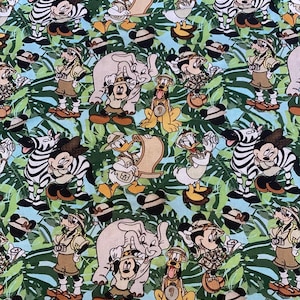 Puede incluir: Tela con un patrón repetido de personajes de Disney con atuendos de safari, incluyendo Mickey Mouse, Minnie Mouse, Donald Duck y Pluto, con cebras y elefantes, sobre un fondo de hojas verdes y azul claro.