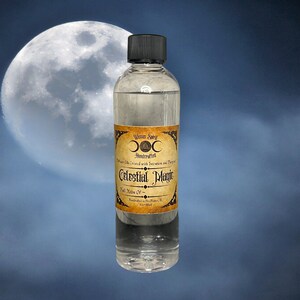 May include: A clear glass bottle with a black cap and a label that reads "Witchcraft Supply", "Handcrafted", "Perfume Oils Created with Intention and Purpose", "Celestial Magic", "Full Moon Oil", and "Handcrafted in Des Plaines, IL 4oz/118ml". The bottle is in front of a full moon and a cloudy sky.