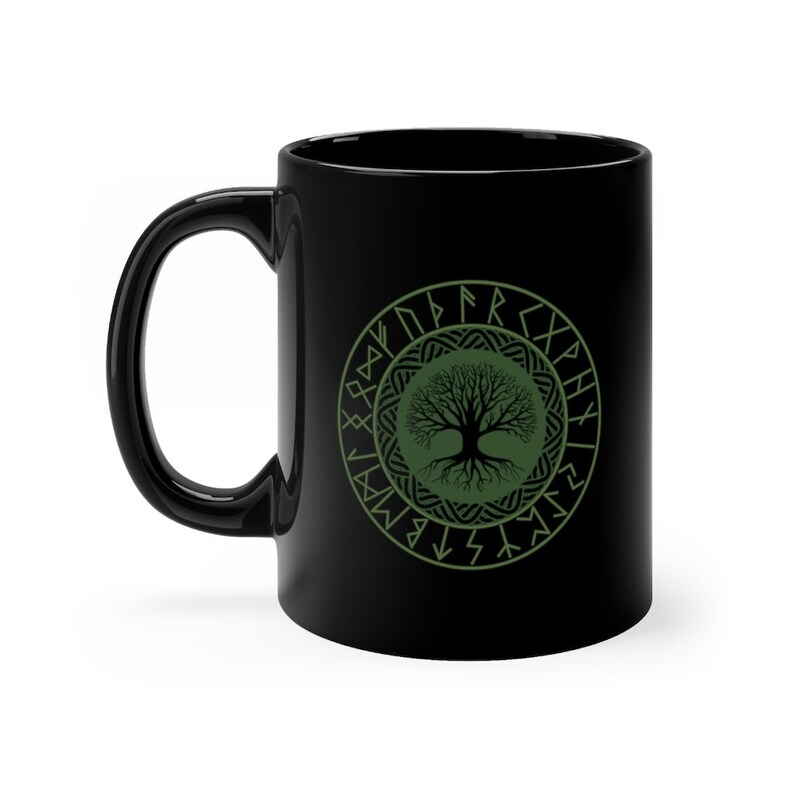 May include: Black ceramic mug with a green tree of life design surrounded by a circle of Norse runes.
