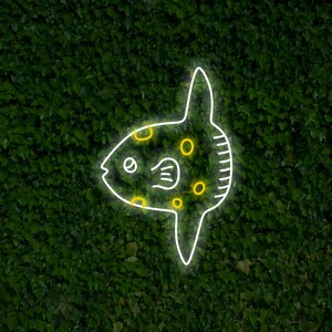 May include: A white neon outline of a fish with yellow circles on a green leafy background.