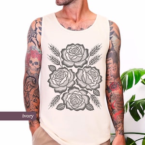 May include: Ivory vest top with a grey floral design of roses and wheat. The graphic is centered on the front. The word "ivory" is printed at the bottom left. A casual, sleeveless top.