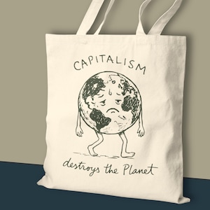 May include: Cream-coloured tote bag featuring a black illustration of a dejected Earth with limbs. The words "CAPITALISM" and "destroys the Planet" are written above and below the Earth image.