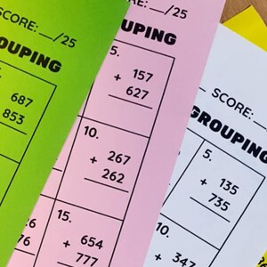 May include: Three worksheets with addition problems for kids. The worksheets are color-coded: green, pink, and yellow. The problems involve adding two-digit numbers with regrouping. The worksheets are titled "Addition with Regrouping".