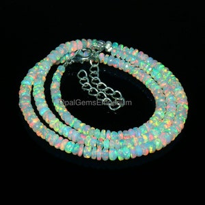 May include: A double strand necklace made of iridescent opal beads. The necklace is silver in colour and has a silver clasp.