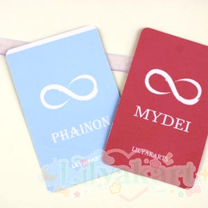 May include: Two rectangular cards, one light blue and one red, with a white infinity symbol. The blue card reads "PHAINON" and the red card reads "MYDEI". The cards are from "LILYAKARTS".