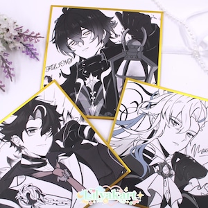 May include: Three square art prints with gold borders, featuring black and white anime-style illustrations of male characters. Each print has a signature. The prints are arranged on a white surface with floral and ribbon accents.