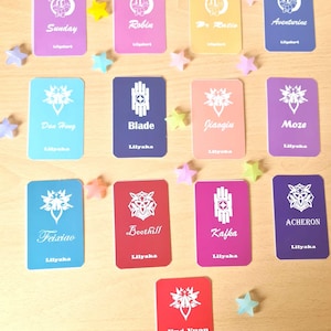 May include: A collection of colorful trading cards with character names and logos, including "Sunday," "Robin," and "Blade." Each card has a unique design and is accompanied by star-shaped decorations.