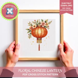 Può includere: Un modello a punto croce incorniciato con un design di lanterna cinese floreale. La lanterna arancione ha accenti floreali e un nappa. La cornice è marrone chiaro. Il testo recita "Floral Chinese Lantern" e "PDF Cross Stitch Pattern."