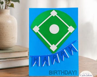 May include: A bright blue greeting card featuring a green baseball diamond graphic with white base markers and a center circle. Below the diamond, a blue pennant banner spells out HAPPY, and the text BIRTHDAY! is printed in blue at the bottom.