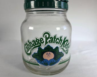Tarro de cristal vintage de 1984 de Cabbage Patch Kids con tapa abatible verde, bote de 15 cm.