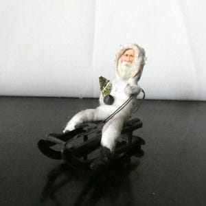 Rara figura antigua de Papá Noel en trineo de algodón con cara de cartón de la década de 1900. Rara figura coleccionable de niño en trineo navideño