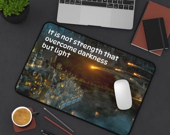 May include: A dark blue mouse mat with a cityscape and a quote that reads "It is not strength that overcome darkness but light".