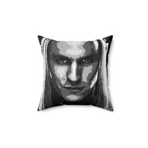 May include: Black and white throw pillow with a graphic print of a person's face.