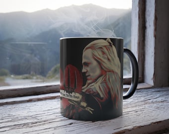 May include: Black ceramic mug featuring a colour image of a man with long white hair and a beard. The man is wearing a dark shirt and has a red heart with the words "My heart, but for my Rings" on it. The mug has a black handle.