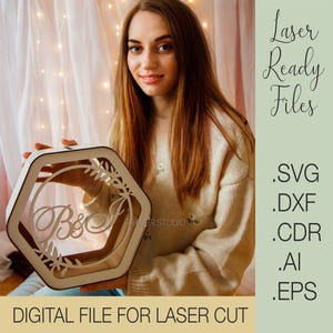 Pode incluir: Uma caixa de madeira hexagonal branca com um design recortado de folhas e as letras "B&J". A caixa está sendo segurada por uma pessoa. O texto "Laser Ready Files" e os tipos de arquivos estão listados no canto superior direito da imagem. O texto "DIGITAL FILE FOR LASER CUT" está na parte inferior da imagem.