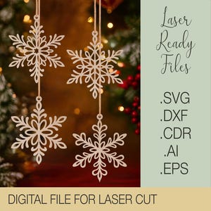 Könnte beinhalten: Vier beige Holz-Schneeflocken-Ornamente, die an Schnüren hängen, mit aufwendigen Ausschnittmustern. Das Bild enthält den Text "Laser Ready Files" und "Digital File for Laser Cut". Der Hintergrund ist verschwommen mit Weihnachtsbeleuchtung.