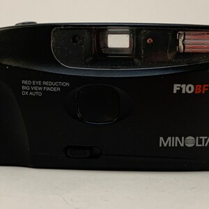 May include: A black Minolta F10BF point-and-shoot camera with a red eye reduction feature, a big view finder, and DX auto settings.
