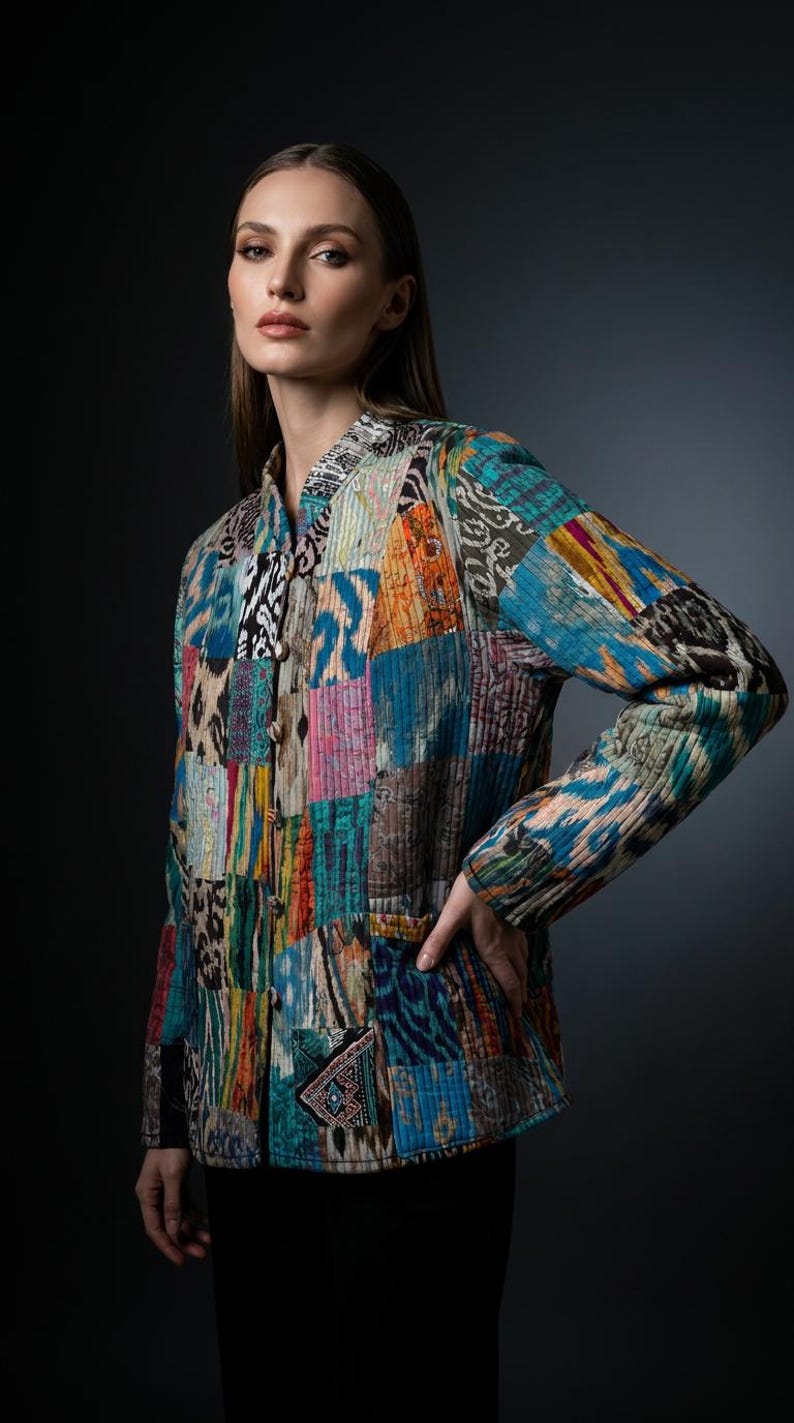 Puede incluir: Una chaqueta acolchada de manga larga con un dise&ntilde;o de patchwork vibrante y varios patrones multicolores, incluyendo azul, amarillo, naranja y negro. La chaqueta tiene un cuello mao, cierre frontal de botones y dos bolsillos inferiores.