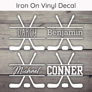 May include: Four iron-on vinyl decals featuring hockey sticks crossed with a name in the center. The names are Darcy, Benjamin, Michael, and Conner.