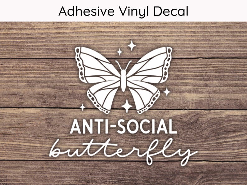 May include: White adhesive vinyl decal featuring a butterfly design with the words "ANTI-SOCIAL butterfly". The decal includes four star accents and the text "Adhesive Vinyl Decal" at the top. The background is a wood grain pattern.