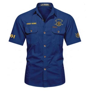 Peut inclure: Chemise bleu marine à manches courtes avec deux poches de poitrine. Le texte "YOUR NAME" est au-dessus de la poche gauche et "YOUR TEMPLE NAME" avec un graphisme à droite. Le chiffre "01" est sur la manche gauche.
