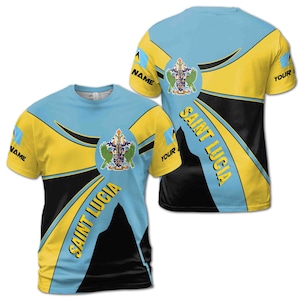 May include: A blue, yellow, and black t-shirt with a graphic of the Saint Lucia flag and coat of arms. The shirt has the text "Saint Lucia" on the front.