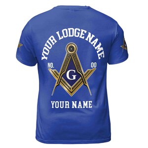 Op de afbeelding: Koninklijk blauw T-shirt met een wit vierkant en kompas ontwerp, met een gouden rand en een blauwe "G" in het midden. De tekst "YOUR LODGE NAME NO. 00" is in wit boven het ontwerp gedrukt, en "YOUR NAME" is in wit onder het ontwerp gedrukt.