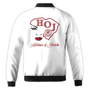 May include: White satin bomber jacket with a red and black design. The design features a stylized outline of South Carolina with the letters "HOJ" inside. The design also includes a red circle with the words "Heroines of Jericho" inside. The text "Heroines of Jericho" is also printed below the design.