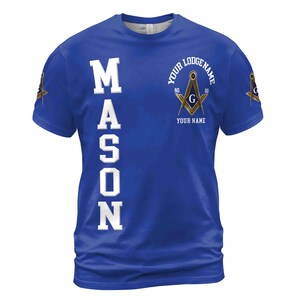 Op de afbeelding: Een koninklijk blauw T-shirt met het woord "MASON" verticaal aan de linkerkant in wit gedrukt. De rechterkant van het shirt heeft een gouden en zwart vrijmetselaars symbool met de tekst "YOUR LODGE NAME" en "YOUR NAME".