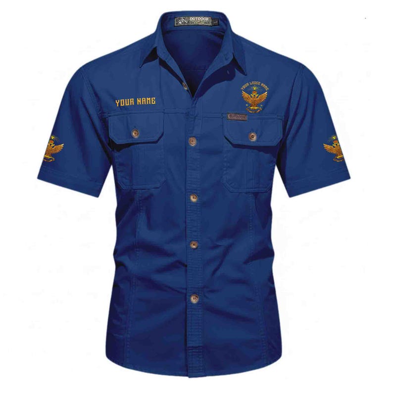 Puede incluir: Camisa azul marino de manga corta con dos bolsillos en el pecho. La camisa presenta &aacute;guilas bordadas en dorado y el texto "YOUR NAME" y "YOUR LITTLE NAME". Tiene un cuello cl&aacute;sico y un estilo casual.