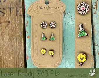 May include: A set of six laser-cut wooden earrings featuring science-themed designs. The earrings are in the shape of a light bulb, a beaker, and an atom. The earrings are displayed on a brown card with the text "I love Science".